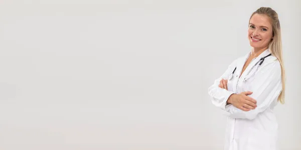 Medico sorridente si trova di fronte alla fotocamera con le mani piegate. Cornice panoramica. — Foto Stock