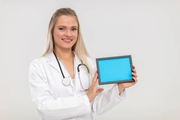 En leende läkare håller en blå plakett i sina händer. — Stockfoto