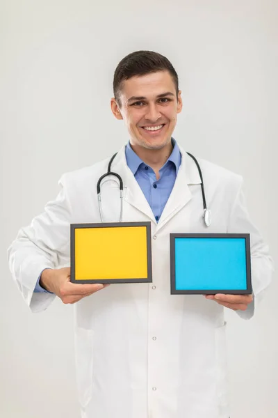 Uram. Az orvos két képkeretet vagy feliratot tart kék és sárga színnel.. — Stock Fotó