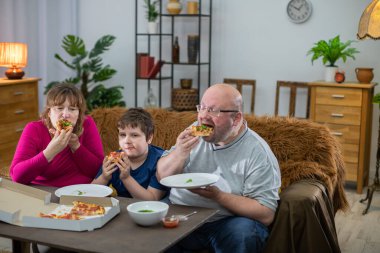 Aile lezzetli sıcak pizzalardan birer dilim yiyor..