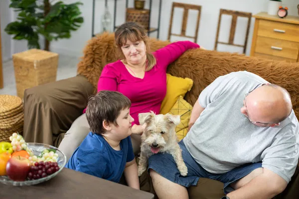 Uma típica imagem de família com um cão durante uma noite de relaxamento e descanso. — Fotografia de Stock