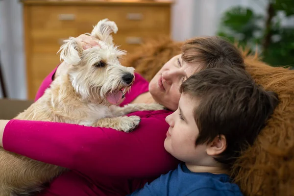 O cão, com a boca aberta e a língua para fora, está sentado nos braços das mães e o filho está ao lado dele.. — Fotografia de Stock