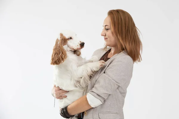 La mujer sostiene al perro en sus brazos y ambos se miran a los ojos. Inglés cocker spaniel with honey gold coat. — Foto de Stock