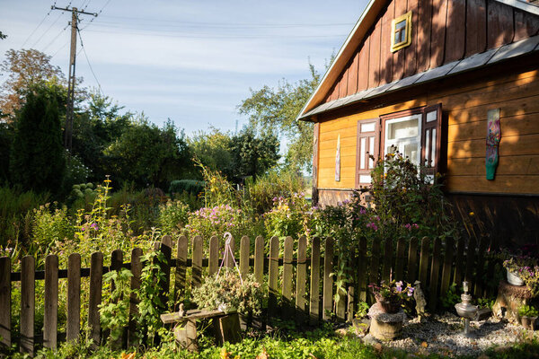 Old country house with garden in the light of the rays of the rising sun.