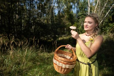 Genç bir kız otların arasında bir mantar buldu, Macrolepiota procera..