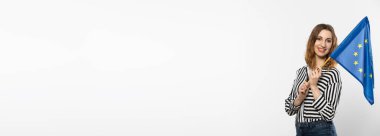Panoramik çerçeve. Avrupa Birliği bayrağı taşıyan çekici bir genç kız. Bir öğrenci Avrupa Birliği bayrağını elinde tutuyor. Beyaz arka planda bayrağı olan bir kadın. Arkaplandan izole edilmiş.