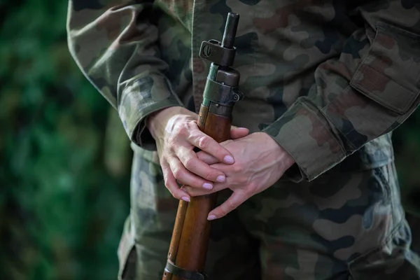 La soldado sostiene un rifle largo justo en el cañón.. — Foto de Stock