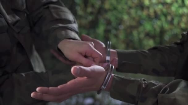 Крупным планом военный снимает наручники. — стоковое видео