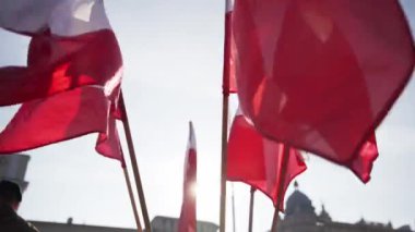 Güneşin altında. Lublin 'deki binaların dış hatlarıyla rüzgarda dalgalanan Polonya bayrakları.