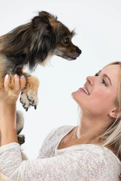 Girl lifted her dog up and they are looking into each others eyes. Portrait of a woman with a dog. Multi-breed dog. — Foto de Stock