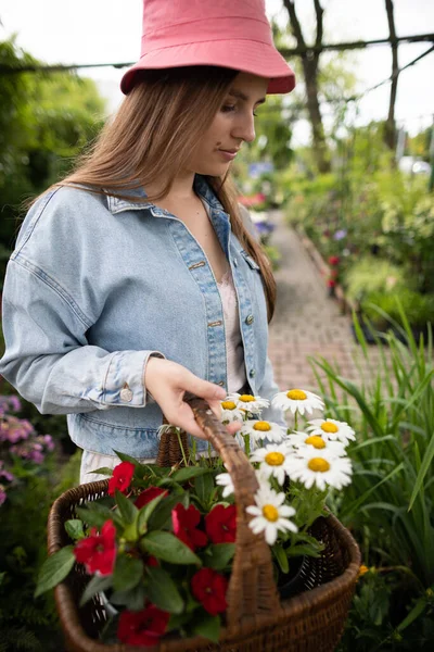 Retrato de uma menina em uma loja de jardim como ela seleciona flores para si mesma. — Fotografia de Stock