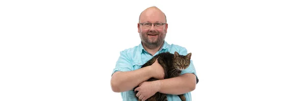 Bald man holds she-cat in his arms and smiles. Panoramic frame. — Stock Photo, Image