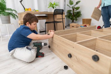 Genç bir çocuk odası için bir kitaplık daha topluyor..