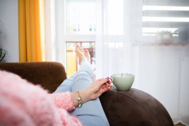 Bir kadının eli büyük bir bardak taze kahveyi tutar..