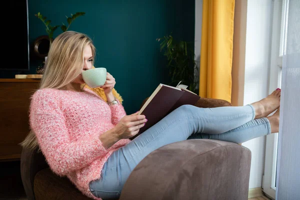 Дівчина відпочиває, читаючи книгу і п'ючи каву . — стокове фото
