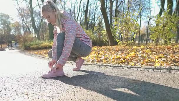 Jogging - En ung kvinna korrigerar sina skor innan hon springer på morgonen. — Stockvideo