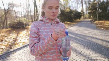 Genç bir kadın plastik su şişesini açamaz..