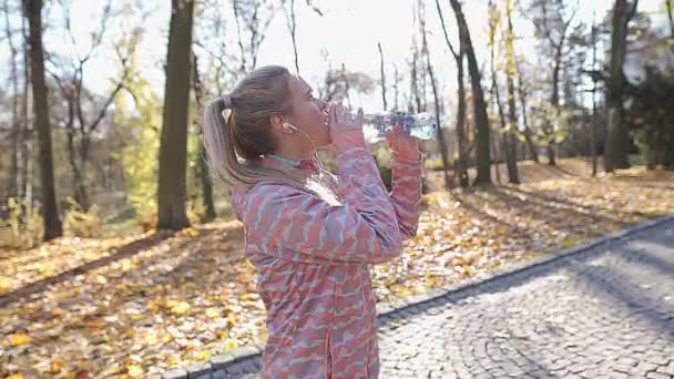 Na een grote training drinkt een meisje water. Goedemorgen joggen. — Stockvideo