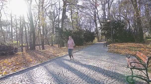 Ein Mädchen läuft einem Entführer durch eine Gasse eines Stadtparks hinterher. — Stockvideo