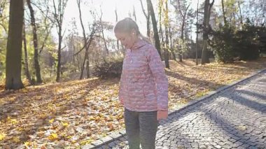 Şehir parkında kollarını ve omuzlarını çalıştıran bir kız..