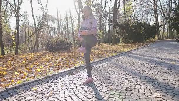 Το κορίτσι στέκεται στο ένα πόδι. Τεντώνει τους μυς της. — Αρχείο Βίντεο