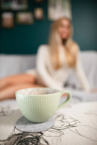 Une tasse de café chaud. Les jambes galbées d'une jolie fille. — Photo