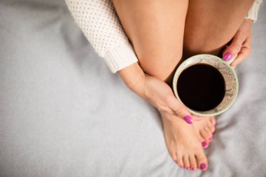 Temiz kadınsı bacaklar ve aromatik kahve. Açık ten.