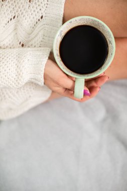 Kahve fincanına yakından bak. Yün çoraplı ince kadın bacakları.