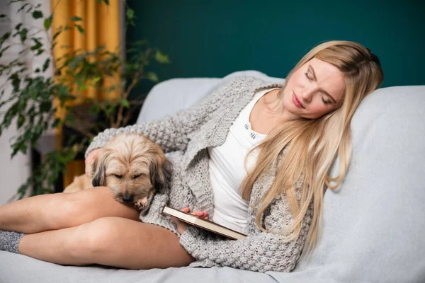 Una joven se quedó dormida mientras leía un libro. Perro de raza múltiple. — Foto de Stock