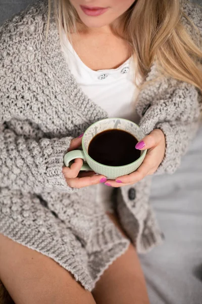 Uma jovem mulher com uma xícara de café de porcelana nas mãos. — Fotografia de Stock