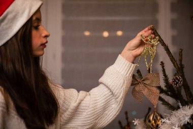 Noel için canlı bir ağacı süsleyen bir gencin yakın çekim görüntüsü.