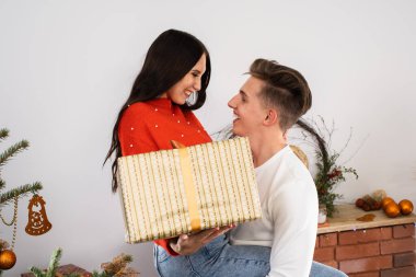 Çocuk sevdiği soya fasulyesini sevinçten kaldırdı. Oturma odasındaki Noel ağacının yanında birbirine aşık bir çift. Eşsiz bir Noel atmosferi.