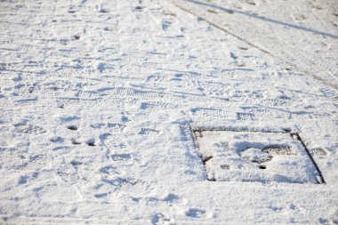 Şehir konutları projesinde tamamen karla kaplı bir kaldırım. Ayakkabı izleri.