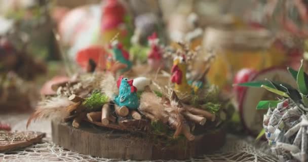 Pasen decoratie van kleurrijke kippen zitten op zitstokken gemaakt van stokken en hooi. — Stockvideo