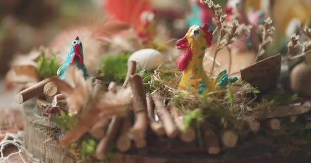 Décoration de Pâques de poules colorées assises sur des perchoirs faits de bâtons et de foin. — Video