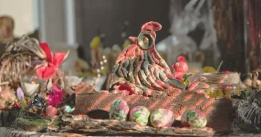 Boyalı bir tavuk renkli Paskalya yumurtalarının yanında oturur. Paskalya dekorasyonu.