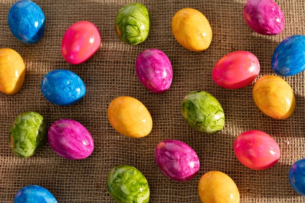Top view of Easter eggs arranged randomly side by side on linen fabric. Easter. — Stock Photo, Image