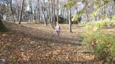 Lublin 'de bir şehir parkında sabah yürüyüşü, gülümseyen bir kadın..