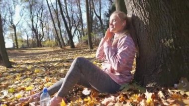 Kız kulaklıklarını düzeltiyor ve güneşli havadan faydalanıyor..