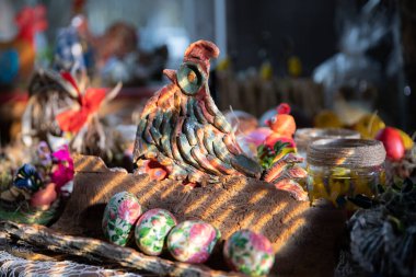 Sanatsal olarak renklerle boyanmış bir tavuk şekli. Birkaç Paskalya yumurtası.