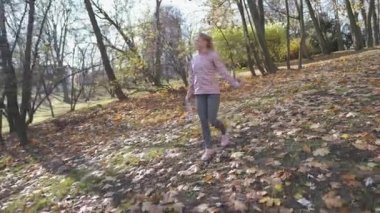 Lublin 'de bir şehir parkında sabah yürüyüşü, gülümseyen bir kadın..