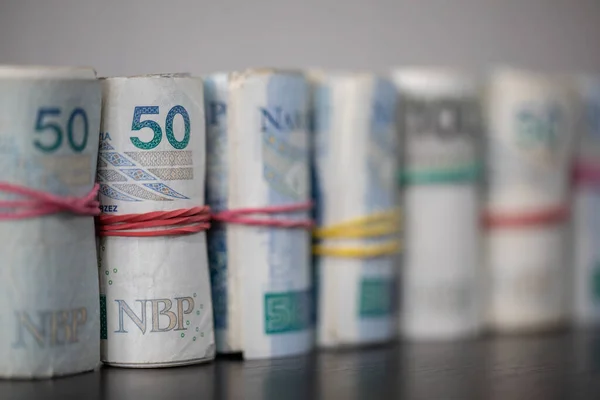 The banknotes rolled and tied together with a rubber band stand on the table top. — Foto Stock