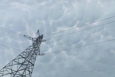 Yüksek voltaj direği, dalgalanan fırtına bulutlarına karşı.