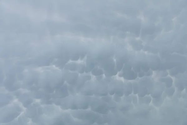 Um grande pedaço de céu repleto de nuvens de tempestade em forma de bolhas. — Fotografia de Stock