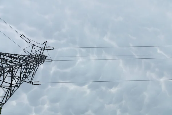 Pôle de transmission aérienne de puissance éclectique sur fond de nuages orageux. — Photo