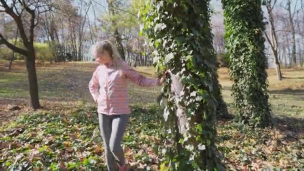 Het meisje bewondert de klimop bedekte boom en de natuur rondom. — Stockvideo