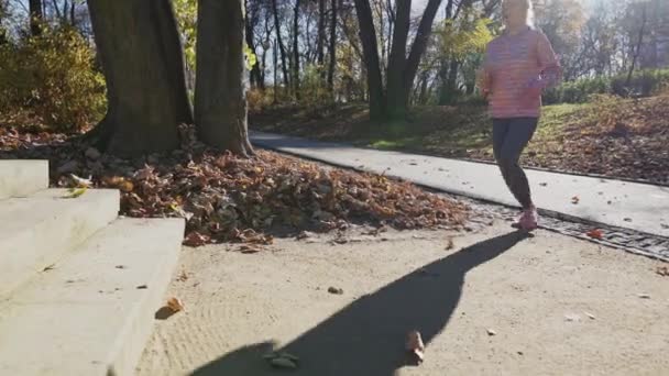 A woman runs to the stairs and practices stretching her leg muscles. — Vídeos de Stock