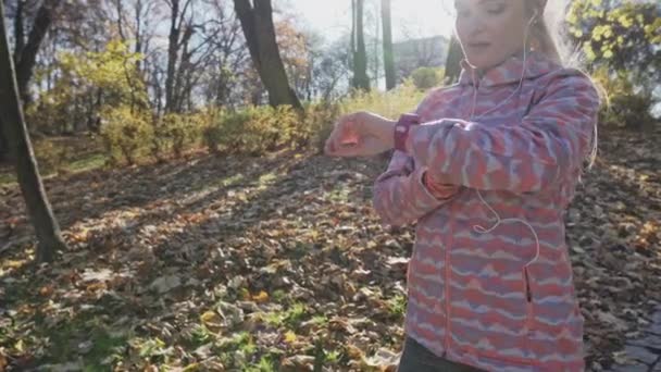 Dívka dokončila jogging a kontroluje své skóre na své chytré. — Stock video