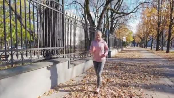 Молодая женщина бежит на ходунке осенью в городе Люблин. — стоковое видео
