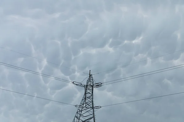 Yüksek voltaj direği, dalgalanan fırtına bulutlarına karşı. — Stok fotoğraf